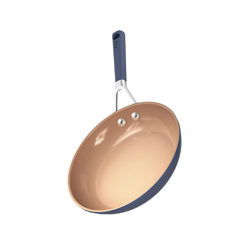 How does the color difference between the blue exterior and orange interior of a ceramic frying pan affect thermal conductivity?